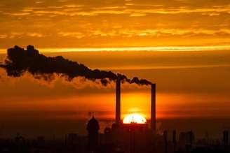 <p>O sol nasce atrás das chaminés de uma estação de energia em Berlim, na Alemanha, em novembro do ano passado</p>