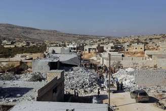 <p>Moradores inspecionam prédios destruídos em Kfredrian, na província de Idlib, que ativistas dizem ter sido atingidos por um ataque dos EUA. 23/9/2014</p>