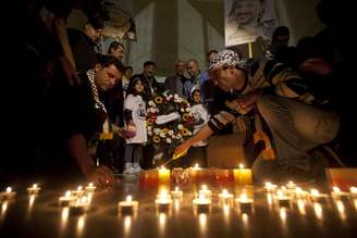 <p>Palestinos acendem velas no túmulo do líder palestino Yasser Arafat  durante o 10º aniversário da sua morte, na cidade de Ramallah, Cisjordânia</p>