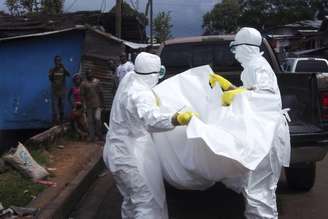 <p>Agentes de saúde removem corpo de homem que provavelmente morreu vítima de Ebola na Libéria</p>