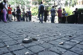 <p>Fragmentos de concreto são vistos fora de um edifício, enquanto moradores da cidade de Manado evacuam para a rua depois do terremoto, na manhã deste sábado, 15 de novembro</p>