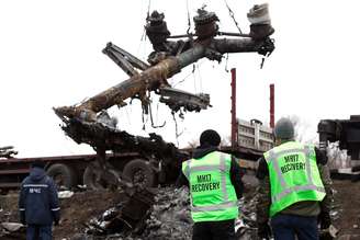 <p>Membros da equipe de especialista holandesa observam enquanto destroços do voo da Malaysia Airlines MH17 são removidos e carregados em um caminhão no local do acidente, no leste da Ucrânia, neste domingo, 16 de novembro</p>