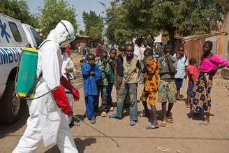 Crianças observam agente pulverizando desinfetante no lado de fora de uma mesquita como parte da luta contra o Ebola, em Bamako, no Mali, no início de novembro. 14/11/2014