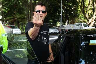 Phil Rudd mostra o dedo para fotógrafo em saída de tribunal 