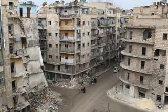 <p>Pessoas caminham em bairro da cidade síria de Aleppo em 10 de dezembro</p>