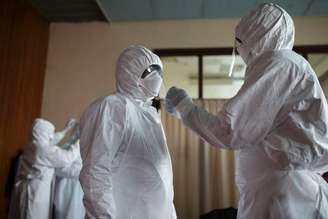<p>Médicos de Serra Leoa vestem roupas protetoras em Freetown, em 16 de dezembro</p>