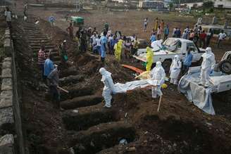 <p>Profissionais de saúde enterram corpo de vítima de Ebola em Freetown, Serra Leoa</p>