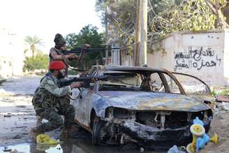 Forças pró-governo da Líbia miram suas armas durante confrontos com os revolucionários líbios, uma aliança formada por  antigos rebeldes anti-Kaddafi, em Benghazi, em 28 de dezembro 