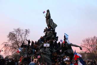 Jovens sobem no monumento 'O Triunfo da República', no fim da marcha pelas ruas de Paris