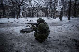 <p>Um rebelde protege uma posição dos separatistas pró-Rússia no bairro de Kievsky, a 3 km do aeroporto de Donetsk, em 22 de janeiro</p>