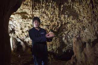 Pesquisador exibe um crânio antigo encontrado dentro de uma caverna israelense