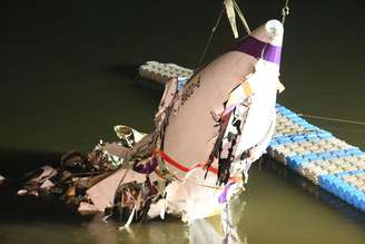 A fuselagem do avião comercial da TransAsia Airways é arrastadapara a margem do rio em Taipei, Taiwan