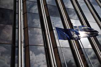 <p>Bandeira da Grécia e da UE em frente a um prédio em Atenas</p>