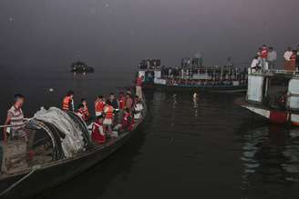 Equipes de resgate procuram sobreviventes de um acidente envolvendo uma balsa com mais de 100 passageiros que afundou no rio Padma, em Bangladesh