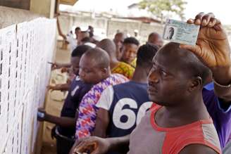 Nigerianos buscam os seus nomes nas listas de eleitores antes de participar da eleição presidencial em Lagos, Nigéria, neste sábado
