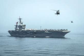 Helicópteros sobrevoam o porta-aviões USS Theodore Roosevelt durante uma missão de reabastecimento no Golfo de Omã. 13/04/2015