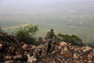 Combatente rebelde monitora o progresso dos confrontos da região de Jabal al-Akrad, na província de Latakia, noroeste da Síria, na quarta-feira. 29/04/2015
