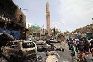 Pessoas observam destroços de carro-bomba em Sanaa, capital do Iêmen. 18/06/2015