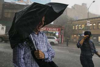 Pedestres se protegendo de forte chuva em Nova York.  23/06/2015