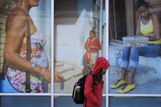 Pedestre passa por painel com fotos de Cuba num prédio de uma universidade em Boston, Estados Unidos. 23/01/2015