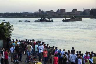 Pessoas observam local de acidente envolvendo dois barcos no Rio Nilo, no Egito