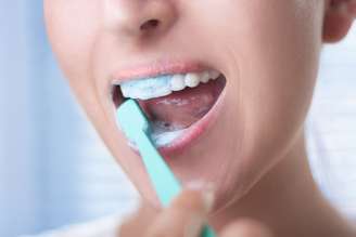A recomendação de escovar os dentes pelo menos três vezes ao dia ocorre por não ser possível garantir que toda pessoa atinja 100% da área dos dentes em uma única escovação diária