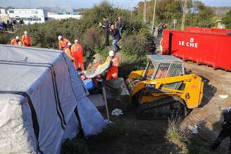 Barracos são desmontados no acampamento de Calais, na França