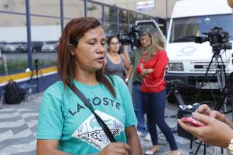 A mulher do vendedor ambulante Luís Carlos Ruas, Maria Aparecida fala com a imprensa em frente ao DHPP, na manhã desta quarta-feira (28).