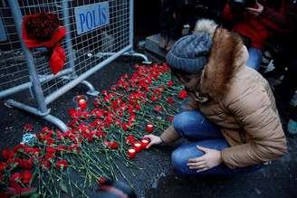 Pessoas depositam flores e velas em barreira em frente à boate Reina onde aconteceu o ataque terrorista no Ano-Novo.