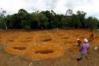 Funcionários de cemitério cavam sepulturas para enterrar as vítimas do massacre no presídio de Manaus