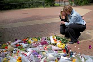 Pessoas depositam flores em homenagem às vítimas de atentado em Manchester.