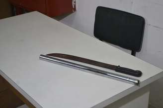 Junto com dois suspeitos, a PM de São Paulo exibe em delegacia um facão e uma barra de ferro utilizados no ataque ao torcedor do Palmeiras