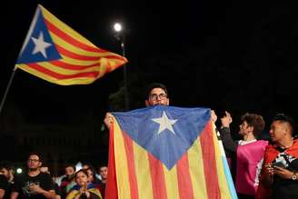 Homem segura bandeira separatista da Catalunha, em Barcelona, Espanha 