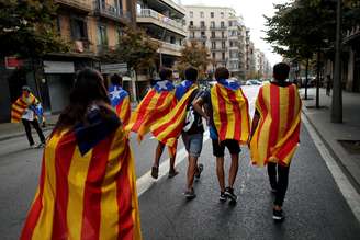 Jovens enrolados em bandeiras separatistas da Catalunha caminham durante protesto em Barcelona 03/10/2017 REUTERS/Jon Nazca