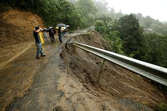 Moradores observam destruição causada pela tempestade em estrada local