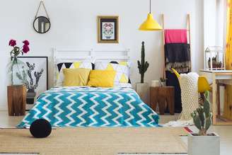 Use composições de almofadas coloridas, quadros e luminárias em tons alegres, como o amarelo, para deixar seu quarto com um ar mais descontraído