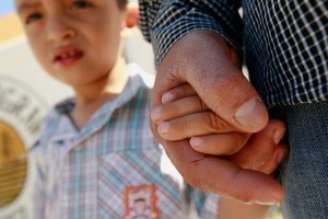 Migrante de El Salvador Epigmenio Centeno segura mão do filho após ter desistido de tentar entrar nos EUA 19/06/2018 REUTERS/Jose Luis Gonzalez