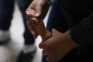 Mulher segura mão de criança à medida que famílias imigrantes são liberadas em McAllen, Texas 22/06/2018 REUTERS/Loren Elliott