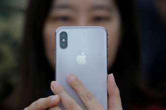 Mulher segura iPhone X durante lançamento em Pequim, China
31/10/2017 REUTERS/Thomas Peter
