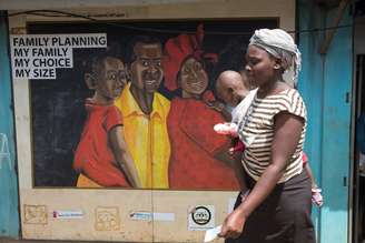 Mulher passa por um murel durante uma visita da Ministra dos Países Baixos para o Comércio e a Cooperação para o Desenvolvimento, Lilianne Ploumen, em uma clínica de Saúde da Família nas favelas de Kibera, em Nairobi, Quênia