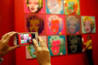 Mulher tira foto com celular de telas de Marilyn Monroe em exposição de Andy Warhol em Londres 10/02/2017 REUTERS/Stefan Wermuth