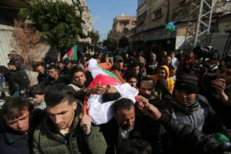Corpo do adolescente palestino Hassan Shalabi, 14, morto durante protesto na fronteira entre Israel e Gaza, é carregado durante funeral na região central de Gaza.