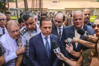 O governador de São Paulo, João Doria (PSDB)(c), fala aos jornalistas após tiroteio ocorrido na Escola Estadual Raul Brasil de Suzano, na Rua Otávio Miguel da Silva, em Suzano, na Grande São Paulo, nesta quarta-feira (13)