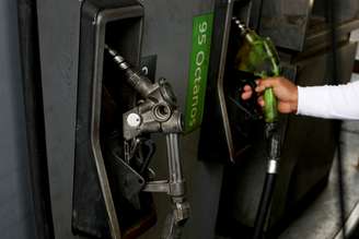 Homem mexe com o bocal de um dispensador de combustível em um posto de gasolina  17/05/2019. REUTERS / Ivan Alvarado