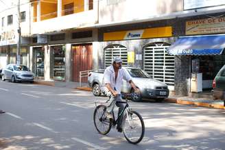 Homem pedala no centro de Barão de Cocais, em Minas Gerais, cidade onde o meio fio de algumas ruas foi pintado de laranja para sinalizar possível trajeto de rejeitos da barragem Sul Superior, da mineradora Vale