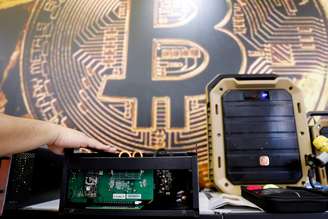Computador minerando é mostrado na frente de logotipo do bitcoin durante exposição emTaipei, Taiwan. 5/6/2018. REUTERS/Tyrone Siu