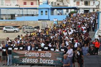 "Estamos no mesmo barco", diz faixa levada durante passeata em memória de vítimas de naufrágio em Lampedusa, sul da Itália