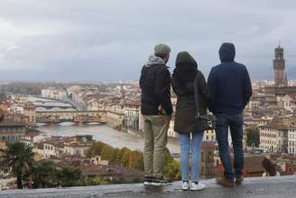 Turistas olham a Ponte Vecchio e o Rio Arno, no centro de Florença