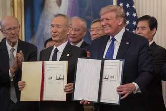 Liu He e Donald Trump exibem assinaturas em acordo comercial