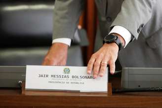 Ministro da Casa CIvil, Walter Souza Braga Netto, retira placa com nome do presidente Jair Bolsonaro de mesa antes de apresentação sobre coronavírus em Brasília
25/03/2020
REUTERS/Ueslei Marcelino